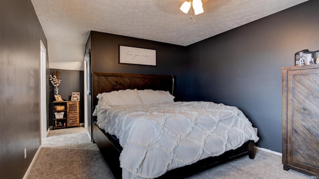 bedroom featuring ceiling fan, light carpet, and a textured ceiling