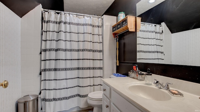 bathroom featuring a shower with shower curtain, vanity, toilet, and a textured ceiling