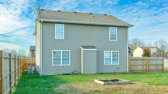 rear view of house featuring a yard and central AC unit