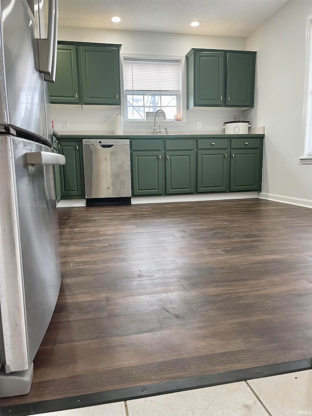 kitchen featuring green cabinets, sink, dark wood-type flooring, and appliances with stainless steel finishes