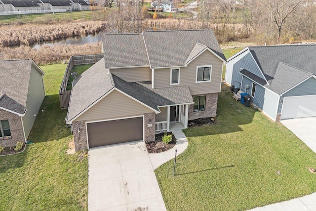 view of front of property featuring covered porch, a water view, and a front lawn