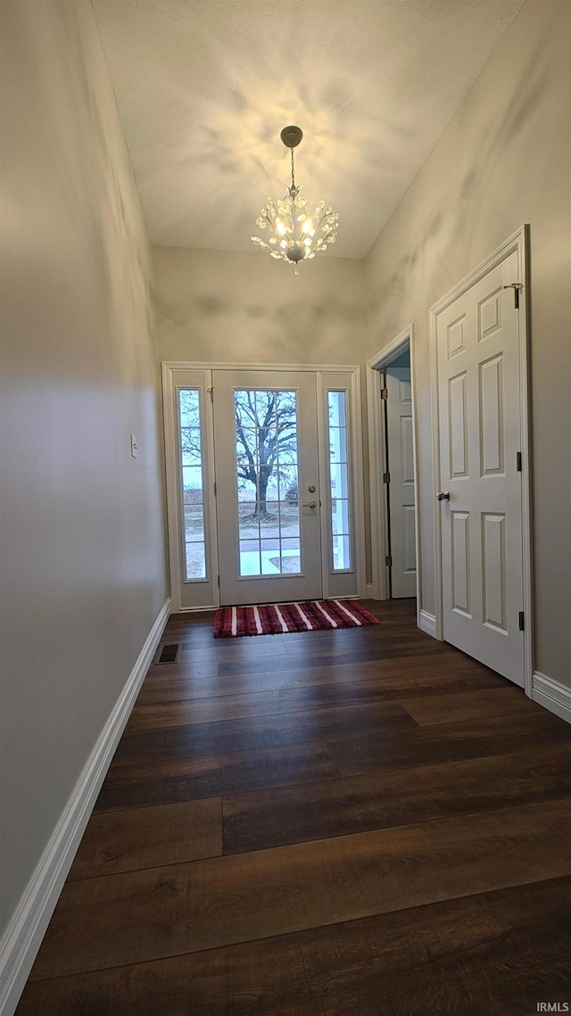 entryway featuring dark hardwood / wood-style floors and a chandelier