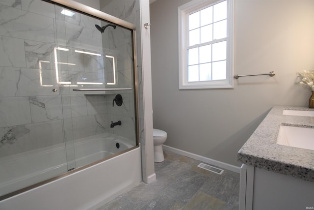 full bathroom featuring vanity, toilet, and bath / shower combo with glass door