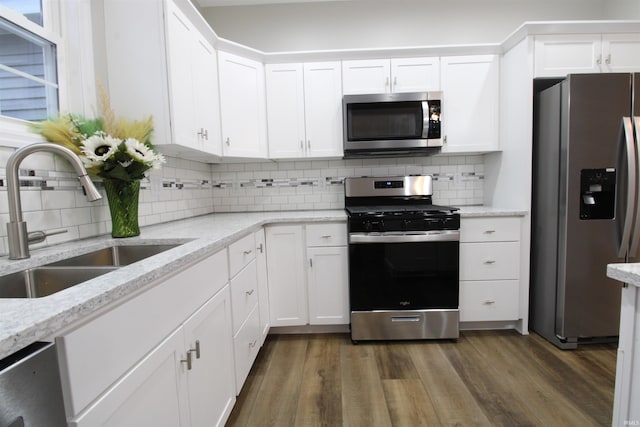 kitchen with white cabinets, sink, stainless steel appliances, and dark wood-type flooring