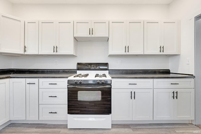 kitchen with white gas stove, white cabinets, and light hardwood / wood-style floors