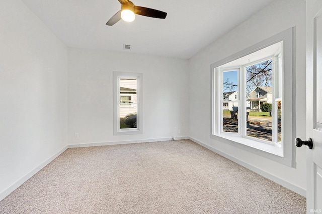 carpeted spare room featuring ceiling fan