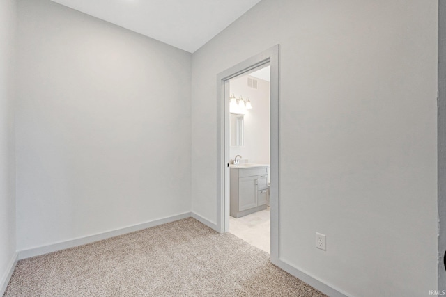 carpeted spare room with sink