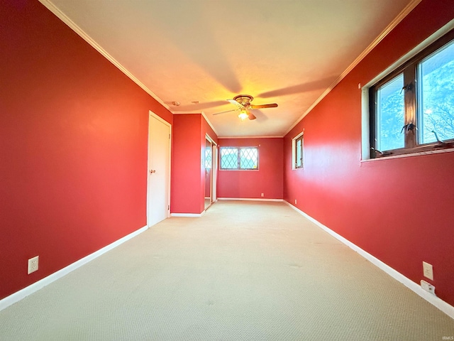 carpeted empty room with ceiling fan and ornamental molding