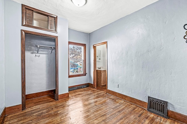 unfurnished bedroom with dark hardwood / wood-style flooring, a closet, and sink