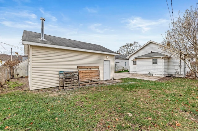 back of house with a patio area and a yard