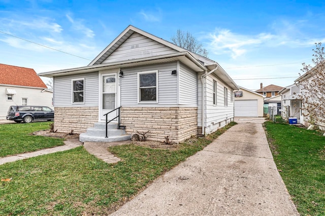 bungalow-style home featuring an outbuilding, a garage, and a front lawn