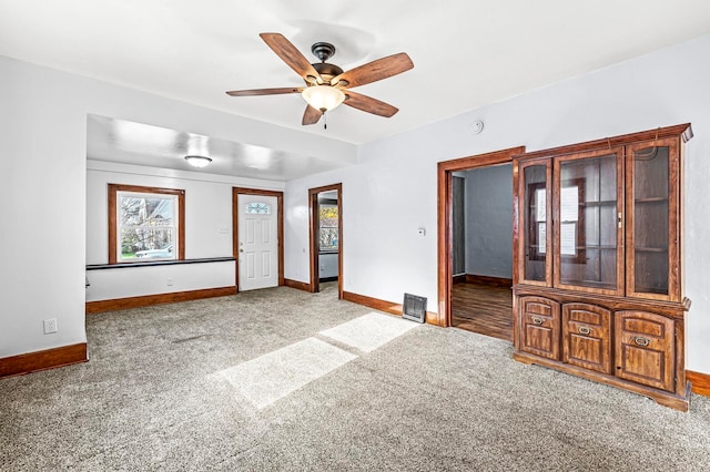 empty room with ceiling fan and carpet floors