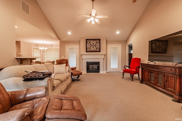 living room with ceiling fan with notable chandelier, light colored carpet, and high vaulted ceiling