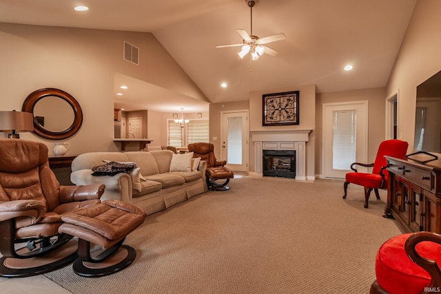 carpeted living room featuring ceiling fan with notable chandelier and high vaulted ceiling