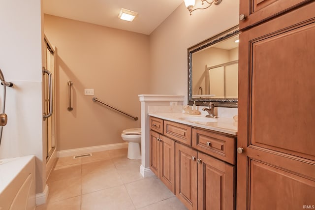 bathroom featuring tile patterned flooring, vanity, a shower with shower door, and toilet