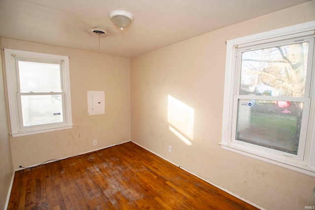 empty room with electric panel and dark wood-type flooring