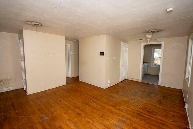 empty room with ceiling fan and dark hardwood / wood-style flooring