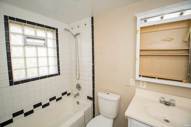 full bathroom featuring tiled shower / bath combo, a healthy amount of sunlight, toilet, and vanity