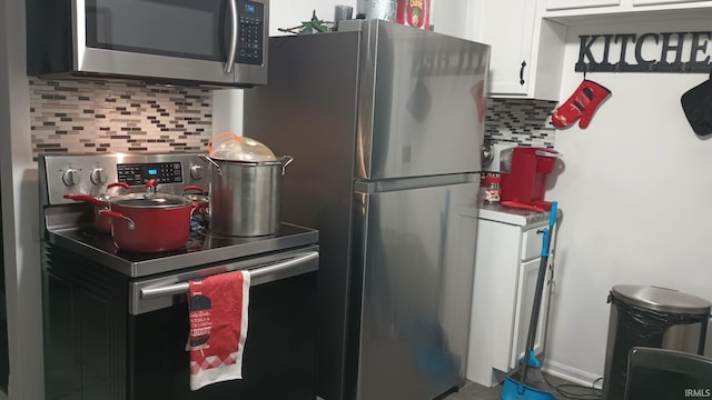 kitchen featuring white cabinets, appliances with stainless steel finishes, and tasteful backsplash