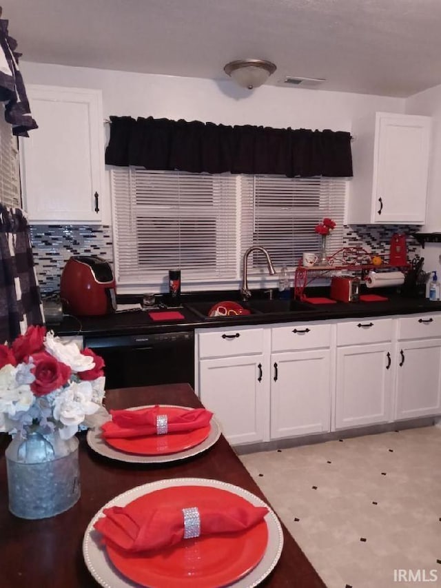 kitchen featuring white cabinets, dishwasher, and backsplash