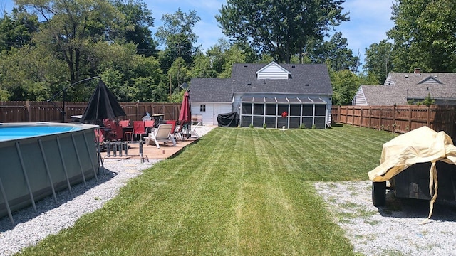 back of house with a fenced in pool and a yard