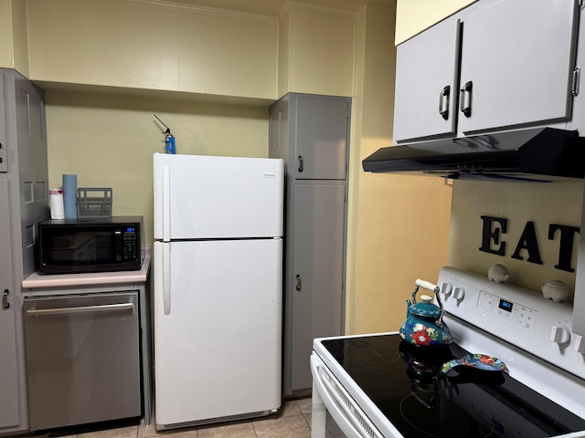 kitchen with white cabinets, white appliances, and light tile patterned flooring