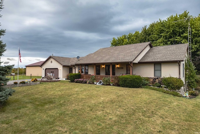 ranch-style home featuring a front lawn, covered porch, and a garage