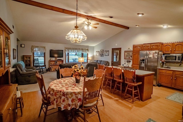 dining area featuring light hardwood / wood-style flooring, lofted ceiling with beams, and ceiling fan with notable chandelier