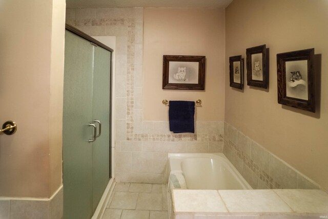 bathroom featuring tile patterned flooring and shower with separate bathtub