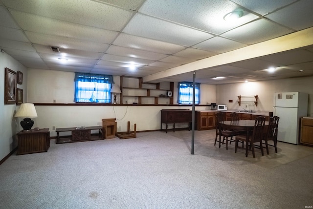 interior space featuring carpet flooring, white refrigerator, and a paneled ceiling