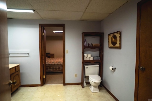 bathroom featuring a drop ceiling, vanity, and toilet