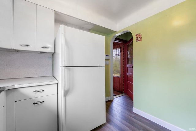 kitchen featuring decorative backsplash, white fridge, white cabinetry, and dark hardwood / wood-style floors