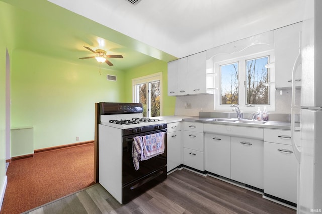 kitchen with white appliances, sink, ceiling fan, dark hardwood / wood-style flooring, and white cabinetry