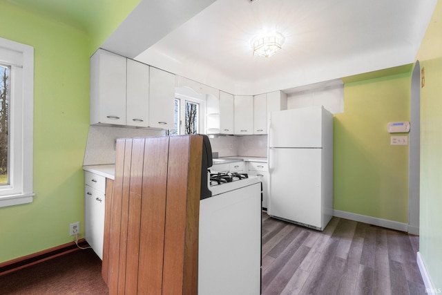 kitchen with white cabinets, plenty of natural light, white refrigerator, and light hardwood / wood-style flooring