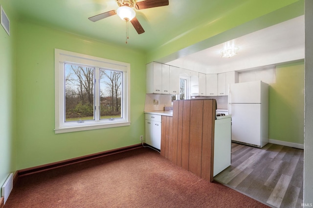 kitchen featuring ceiling fan with notable chandelier, white fridge, white cabinetry, and light hardwood / wood-style flooring