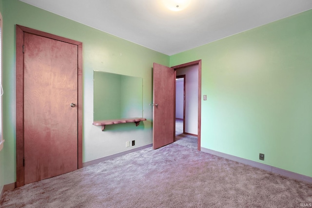 unfurnished bedroom with a closet and light colored carpet