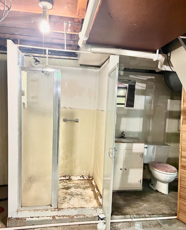 bathroom with vanity, toilet, an enclosed shower, and concrete floors