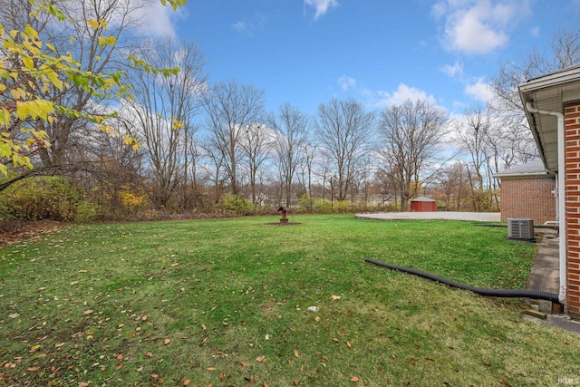 view of yard featuring a shed and central AC