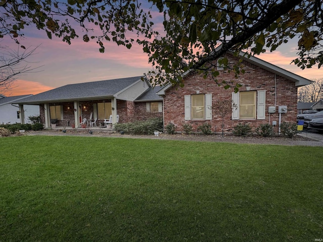 view of front facade with covered porch and a lawn