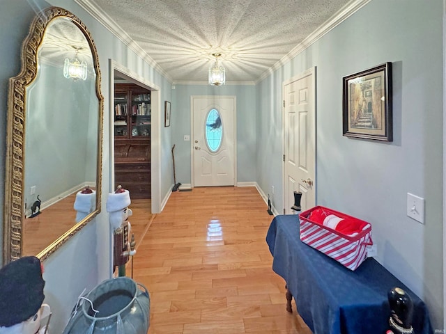 foyer entrance featuring wood-type flooring, a textured ceiling, and ornamental molding