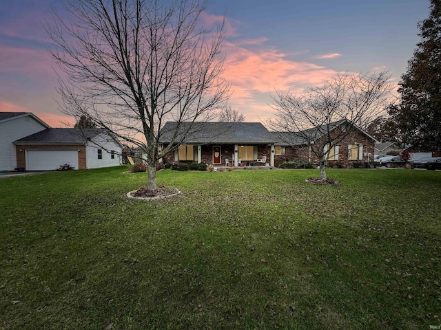 ranch-style house featuring a lawn, a porch, and a garage