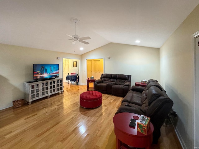 living room with ceiling fan, wood-type flooring, and vaulted ceiling