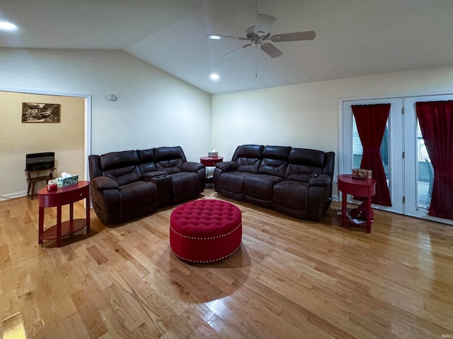 living room with ceiling fan, light hardwood / wood-style flooring, and vaulted ceiling