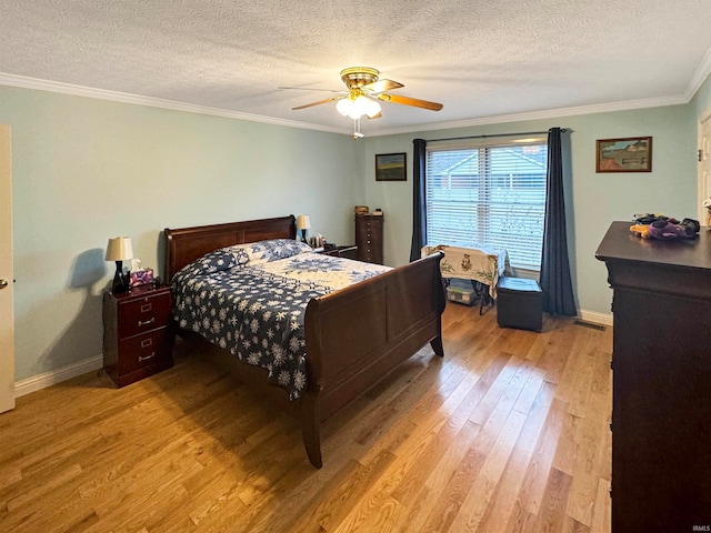 bedroom featuring ceiling fan, ornamental molding, a textured ceiling, and light wood-type flooring