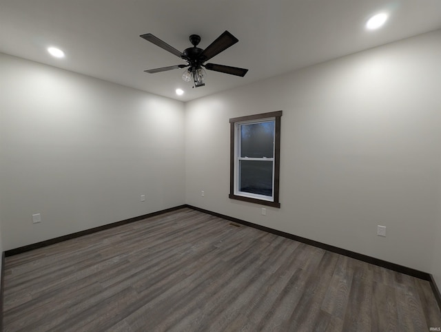 empty room featuring ceiling fan and dark hardwood / wood-style flooring