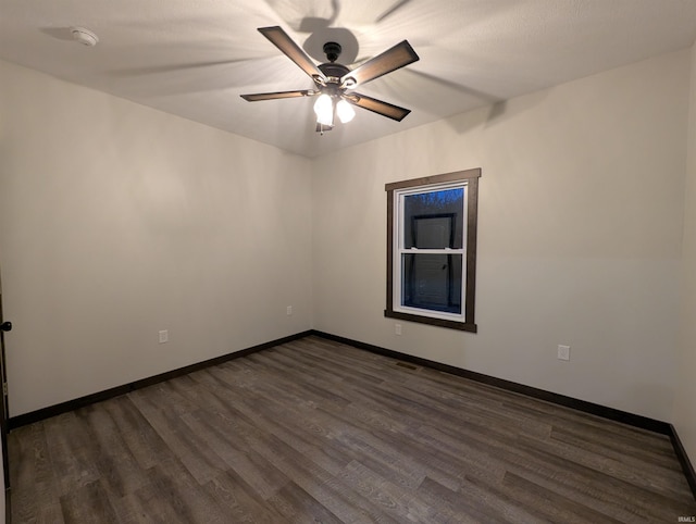 spare room with ceiling fan and dark wood-type flooring