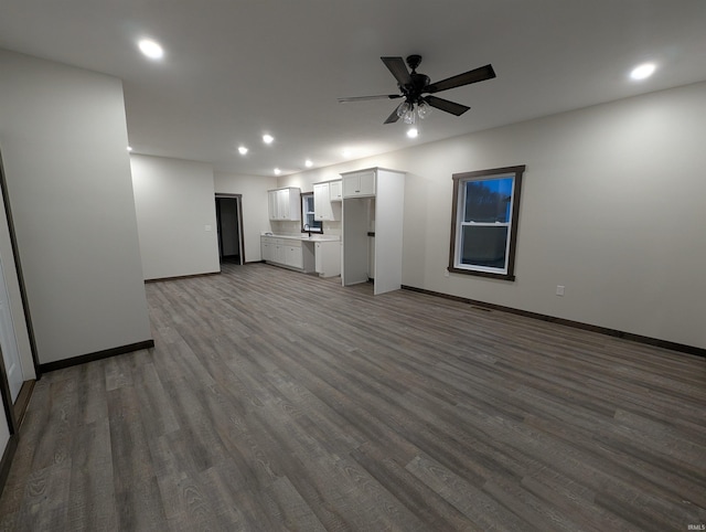 unfurnished living room with ceiling fan and dark hardwood / wood-style flooring