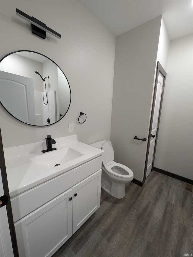 bathroom with vanity, hardwood / wood-style flooring, toilet, and walk in shower