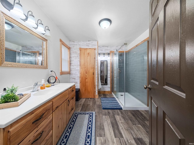 bathroom featuring wood-type flooring, vanity, and a shower with door