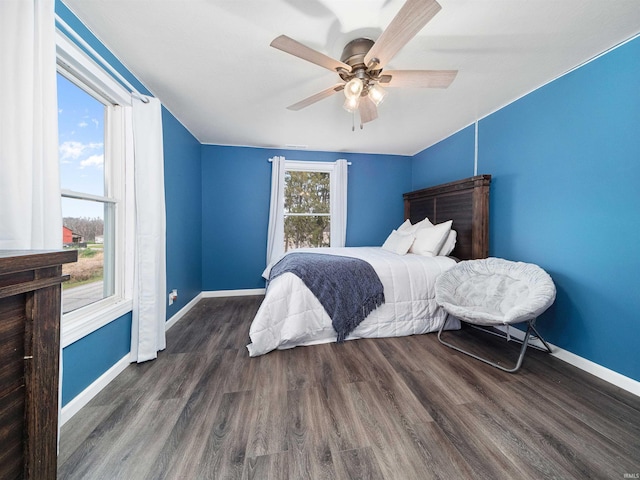 bedroom with multiple windows, ceiling fan, and dark wood-type flooring